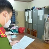Nguyễn Thị Kim Hạnh (tức Mười Tường) nghe công an đọc quyết định khởi tố. (Ảnh: TTXVN)