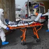 Nhân viên y tế chuyển bệnh nhân COVID-19 vào bệnh viện ở Vacsava (Ba Lan). (Ảnh: AFP/TTXVN)