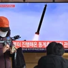 Người dân theo dõi bản tin tại Nhà ga Seoul (Hàn Quốc) về vụ phóng vật thể bay không xác định của Triều Tiên hướng ra Biển Nhật Bản, ngày 5/1/2022. (Ảnh: AFP/TTXVN)