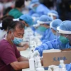 Nhân viên y tế lấy mẫu xét nghiệm COVID-19 cho người dân tại tỉnh Quảng Đông (Trung Quốc). (Ảnh: THX/TTXVN)