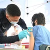 Nhân viên y tế tiêm vaccine ngừa COVID-19 cho người dân tại Los Angeles (Mỹ). (Ảnh: AFP/TTXVN)