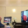 Tổng thống Nga Vladimir Putin và Tổng thống Pháp Emmanuel Macron (trên màn hình) trong một cuộc gặp trực tuyến, ngày 26/6/2020. (Ảnh: AFP/TTXVN)