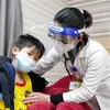 Bác sỹ Khoa Nhi, Bệnh viện đa khoa Hùng Vương thăm khám cho cháu Phạm Quốc C. (Ảnh: TTXVN)