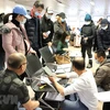 Cán bộ Đại sứ quán Việt Nam kiểm tra, cấp thẻ thông hành cho kiều bào ở sân bay thủ đô Bucharest (Romania). (Ảnh: Mạnh Hùng/TTXVN)