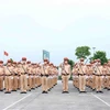 Cán bộ, chiến sỹ Cảnh sát Giao thông thực hiện nghi thức chào cờ tại buổi lễ. (Ảnh: Phạm Kiên/TTXVN)