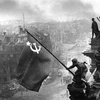Chiến sỹ Hồng quân thuộc Phương diện quân Byelorussia 1 cắm lá cờ chiến thắng lên nóc Nhà Quốc hội Đức, chiều 30/4/1945. (Ảnh: Tư liệu quốc tế/TTXVN phát)
