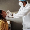Nhân viên y tế lấy mẫu xét nghiệm COVID-19 cho người dân tại Richmond, Johannesburg (Nam Phi). (Ảnh: AFP/TTXVN)