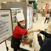Nhân viên giới thiệu đồ ăn cho khách tại một siêu thị ở Seoul (Hàn Quốc) ngày 25/4/2022, khi hoạt động ăn uống được phép nối lại tại đây. (Ảnh: Yonhap/TTXVN)