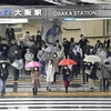 Người dân đeo khẩu trang phòng dịch COVID-19 khi đi trên đường phố ở Osaka (Nhật Bản), ngày 22/3/2022. (Ảnh: Kyodo/TTXVN)