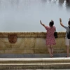 Người dân tránh nóng bên vòi phun nước tại Seville (Tây Ban Nha), ngày 10/7/2021. (Ảnh: AFP/TTXVN)