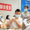Nhân viên y tế tiêm vaccine ngừa COVID-19 cho học sinh tại Quý Châu (Trung Quốc). (Ảnh: THX/TTXVN)