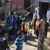 Nhân viên pháp y chuyển thi thể nạn nhân ra khỏi quán rượu ở thành phố Đông London, miền Nam của Nam Phi, ngày 26/6/2022. (Ảnh: AFP/TTXVN)