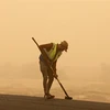 Công nhân dọn trên một tuyến đường sau trận bão cát ở tỉnh Diyala (Iraq), ngày 3/7/2022. (Ảnh: AFP/TTXVN)