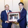 Thủ tướng Nguyễn Xuân Phúc tặng bức ảnh chụp chung với Thủ tướng Abe Shinzo tại Hội An (Quảng Nam) trong dịp ông Abe tham dự Hội nghị Cấp cao APEC năm 2017 (Tokyo, 1/7/2019). (Ảnh: Thống Nhất/TTXVN)