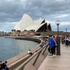 Du khách tham quan Nhà hát Opera Sydney (Australia). (Ảnh: AFP/TTXVN)