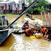 Cán bộ, chiến sỹ Đồn Biên phòng Vĩnh Gia trục vớt phương tiện và hàng hóa bị chìm trên kinh Vĩnh Tế. (Ảnh: TTXVN phát)