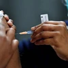 Nhân viên y tế tiêm vaccine phòng COVID-19 cho người dân tại Sydney (Australia). (Ảnh: AFP/TTXVN)