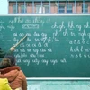 Chiến sỹ biên phòng giúp phụ nữ đồng bào dân tộc Pa Cô-Vân Kiều trên địa bàn xã A Dơi, huyện Hướng Hóa (Quảng Trị) biết đọc, biết viết. (Ảnh: TTXVN)