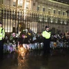 Người dân đặt hoa và nến tưởng niệm dọc theo hàng dào bảo vê bên ngoài Cung điện Buckingham. Ảnh: Hải Vân - PV TTXVN tại Vương quốc Anh