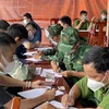 Bộ đội Biên phòng và Công an tỉnh Tây Ninh làm các thủ tục tiếp nhận người lao động tự do tại Campuchia trở về nước. (Ảnh: TTXVN phát)