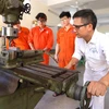 Hướng dẫn sinh viên thực hành gia công cơ khí tại Trường cao đẳng Hàng hải (Hải Phòng). (Ảnh: Hoàng Hiếu/TTXVN)