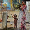 Người dân giải nhiệt tại một vòi nước công cộng trong thời tiết nắng nóng tại Allahabad (Ấn Độ), ngày 28/4/2022. (Ảnh: AFP/TTXVN)
