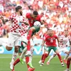 Achraf Hakimi (trên, phải) của Maroc tranh bóng với các cầu thủ đội Croatia. (Ảnh: THX/TTXVN)
