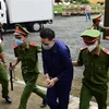 Dẫn giải bị cáo Nguyễn Kim Trung Thái tới Toà. Ảnh: Thanh Vũ - TTXVN