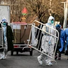 Nhân viên y tế di chuyển các thanh chốt chặn tại khu vực được dỡ bỏ lệnh phong tỏa do COVID-19 ở Bắc Kinh (Trung Quốc) ngày 9/12/2022. (Ảnh: AFP/TTXVN)