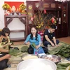 Bà Ma Thị Kim Cương cùng gia đình, bạn bè và con cháu đang cùng góp bánh chưng để ăn tết theo phong tục truyền thống của Việt Nam. (Ảnh: Bá Thành/TTXVN)