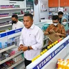 Nhà chức trách kiểm tra thuốc siro ho tại một hiệu thuốc ở Banda Aceh (Indonesia), ngày 24/10/2022. (Ảnh: AFP/TTXVN)