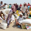 Người dân nhận hàng cứu trợ tại một trại tị nạn ở thành phố Hodeidah (Yemen) ngày 31/8/2022. (Ảnh: AFP/TTXVN)