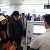 Hành khách làm thủ tục an ninh tại sân bay quốc tế Nội Bài. (Ảnh minh họa: Huy Hùng/TTXVN)