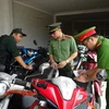 Các đơn vị nghiệp vụ kiểm tra, xác minh xe môtô cầm cố chưa đúng quy định tại kho của một cơ sở cầm đồ xã An Phước, huyện Long Thành (Đồng Nai). (Nguồn: Công an nhân dân)
