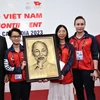 Phó Thủ tướng Chính phủ Trần Lưu Quang tặng bức chân dung Chủ tịch Hồ Chí Minh, động viên tinh thần thi đấu của Đoàn Thể thao Việt Nam tại SEA Games 32. (Ảnh: Huỳnh Thảo/TTXVN)