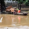 Người dân di chuyển bằng thuyền trên đường phố ngập lụt do mưa lớn tại Kinshasa (Cộng hòa Dân chủ Congo). (Ảnh: AFP/TTXVN)