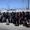 Người di cư chờ xét duyệt bên ngoài Cơ quan kiểm soát biên phòng Mỹ, sau khi vượt qua biên giới Mexico vào El Paso, bang Texas (Mỹ), ngày 9/5/2023. (Ảnh: AFP/TTXVN)