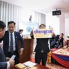 Các quan chức và nhân viên Ủy ban Bầu cử Quốc gia Campuchia giới thiệu thùng phiếu tại lễ bốc thăm. (Ảnh: Huỳnh Thảo/TTXVN)