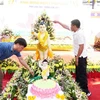Các chư tôn giáo phẩm Việt Nam, Lào cùng bà con Phật tử và người Việt tại thủ đô Vientiane thực hiện nghi lễ tắm Phật. (Ảnh: Đỗ Bá Thành/TTXVN)