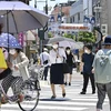 Người dân di chuyển dưới tiết trời nắng nóng tại Tokyo (Nhật Bản). (Ảnh: Kyodo/TTXVN)