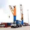Bốc dỡ hàng hóa lên sà lan tại cụm cảng biển Cái Mép-Thị Vải. (Ảnh: Hồng Đạt/TTXVN)