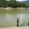 Công nhân Công ty Trách nhiệm Hữu hạn Quản lý Thủy Nông Điện Biên kiểm tra mực nước tại hồ Hồng Sạt. (Ảnh: Xuân Tư/TTXVN)
