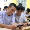 Em Nguyễn Mạnh Hùng (trái) và em Đặng Tuấn Anh xem điểm thi Kỳ thi Tốt nghiệp Trung học Phổ thông năm 2023. (Ảnh: Đinh Văn Nhiều/TTXVN)