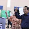 Chủ tịch CPP-Thủ tướng Hun Sen và phu nhân với ngón tay trỏ đã điểm chỉ bằng mực không tẩy xóa được, đánh dấu hoàn thành quyền và nghĩa vụ bầu cử của mình. (Ảnh: Quang Anh/TTXVN)