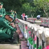 Đoàn viên thanh niên Lực lượng Vũ trang dâng hương lên các phần mộ Liệt sỹ tại Nghĩa trang Liệt sỹ Dốc Bà Đắc, xã Thới Sơn, thị xã Tịnh Biên (tỉnh An Giang). (Ảnh: Công Mạo/TTXVN)
