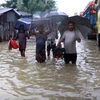 Người dân di chuyển trên con phố bị ngập lụt tại Chattogram (Bangladesh) ngày 8/8/2023. (Ảnh: THX/TTXVN)