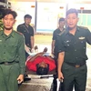 Bộ đội Biên phòng Cà Mau hỗ trợ thuyền viên bị thương ở chân lên xe về tỉnh Kiên Giang. (Ảnh: TTXVN phát)