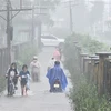 Ngập lụt ở Thừa Thiên-Huế khiến người dân gặp khó khăn khi tham gia giao thông. (Ảnh: Mai Trang/TTXVN)