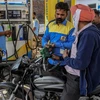 Khách hàng đổ xăng tại một trạm xăng ở Amritsar (Ấn Độ). (Ảnh: AFP/TTXVN)