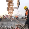 Công nhân làm việc tại công trình xây dựng ở Trùng Khánh (Trung Quốc). (Ảnh: THX/TTXVN)
